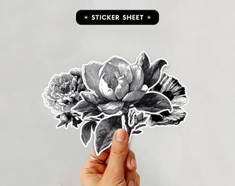 May include: A black and white sticker sheet featuring a floral design. The sticker sheet has a black banner at the top with the words "STICKER SHEET". The floral design includes a peony, magnolia, and other flowers.