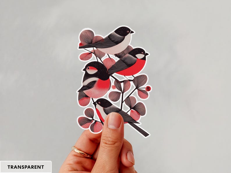 A beautiful and minimal illustration of four finches perched in a tree. Design is black, red and cream, printed on a kiss-cut vinyl sticker with a transparent  border. Sticker is being held by a single hand on a neutral, light grey background.