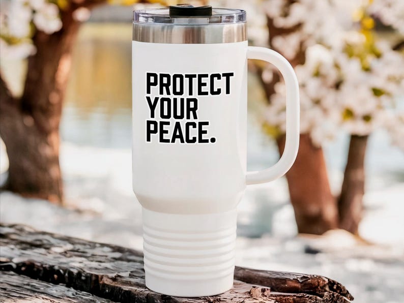 A bold typographic design reading PROTECT YOUR PEACE. Design is printed on a kiss-cut vinyl sticker with a white border. Sticker is shown on a tall white tumbler in a luxurious outdoor setting.