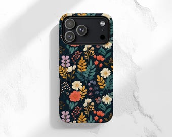 May include: A smartphone case featuring a dark navy blue background with a repeating pattern of various flowers and leaves in shades of coral, yellow, cream, and teal. The case has a black camera module cutout at the top with three circular lenses.