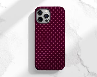 May include: A smartphone case with a dark burgundy background and a pattern of small, evenly spaced pink polka dots. The case has a dark border and cutouts for the camera and other features.
