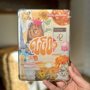 Puede incluir: Una funda transparente para teléfono con un collage de imágenes, que incluye un león, un girasol, una puesta de sol y el texto "Leo" en una fuente retro. El texto "Main character" y "Priorities" también es visible en la funda.