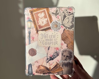 May include: A pink and white book cover with a clear protective case. The cover features a variety of vintage-style images, including a butterfly, a stamp, a quill pen, and a book. The text "Just one more chapter" is written in black cursive lettering.