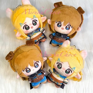 May include: Four plush character keychains featuring two figures with yellow hair and pointed ears, and two figures with brown hair and rounded ears. Each plush has large embroidered eyes, a small nose, and detailed blue and brown clothing.