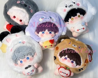 May include: Five plush dolls with embroidered facial features, each wearing a soft animal-themed hood. The dolls feature varied hair colors and are dressed in hoods resembling a gray seal, a white bear, a purple creature, a white panda, and a brown bear.