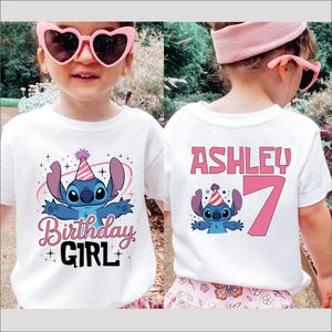 A young girl wearing a white t-shirt with a character from the Lilo and Stitch movie, sunglasses, and a pink headband.