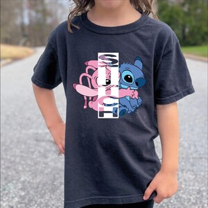 a little girl standing in the middle of a road