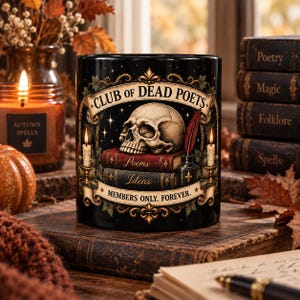 Op de afbeelding: Een zwarte keramische mok met een afbeelding van een menselijke schedel op twee boeken met de titels Poems en Ideas. Het ontwerp bevat een rode veer, inktpot en twee brandende kaarsen. Tekst: CLUB OF DEAD POETS en MEMBERS ONLY. FOREVER.