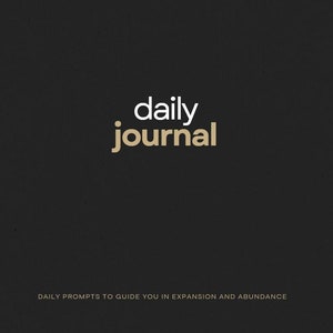 May include: Black and white text on a dark grey background. The text reads "QUANTUM JOURNEY" in a smaller font at the top and "daily journal" in a larger font in the centre. The text at the bottom reads "DAILY PROMPTS TO GUIDE YOU IN EXPANSION AND ABUNDANCE".