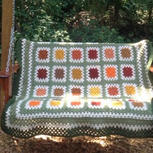 May include: A green and white crocheted swing seat with a checkered pattern of orange, red, and brown squares.