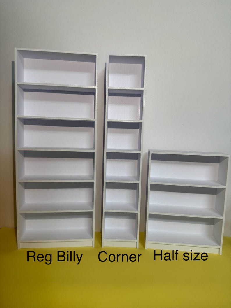 May include: Three white bookshelves of different sizes. The largest bookshelf is labeled "Reg Billy", the middle bookshelf is labeled "Corner", and the smallest bookshelf is labeled "Half size".