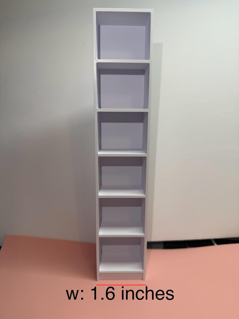 May include: White bookshelf with six shelves. The bookshelf is 1.6 inches wide.