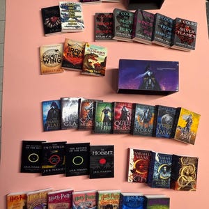 May include: A collection of miniature paperback books, including titles like "A Court of Mist and Fury", "The Hobbit", "Harry Potter and the Goblet of Fire", and "Iron Flame".
