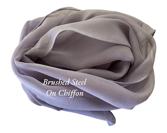 May include: A soft, gray chiffon scarf with the text "Brushed Steel On Chiffon" printed on it.