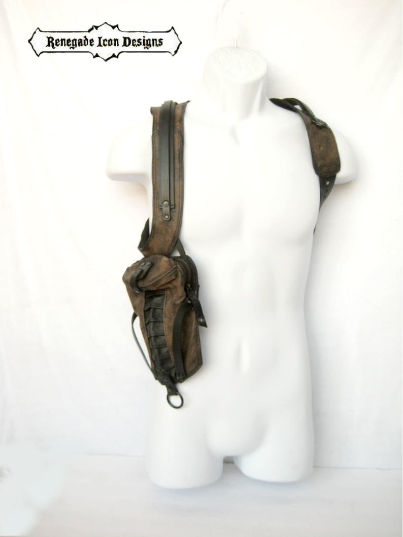 May include: A brown leather shoulder bag with a black strap and zipper. The bag has a small pocket on the front and is worn on a mannequin.