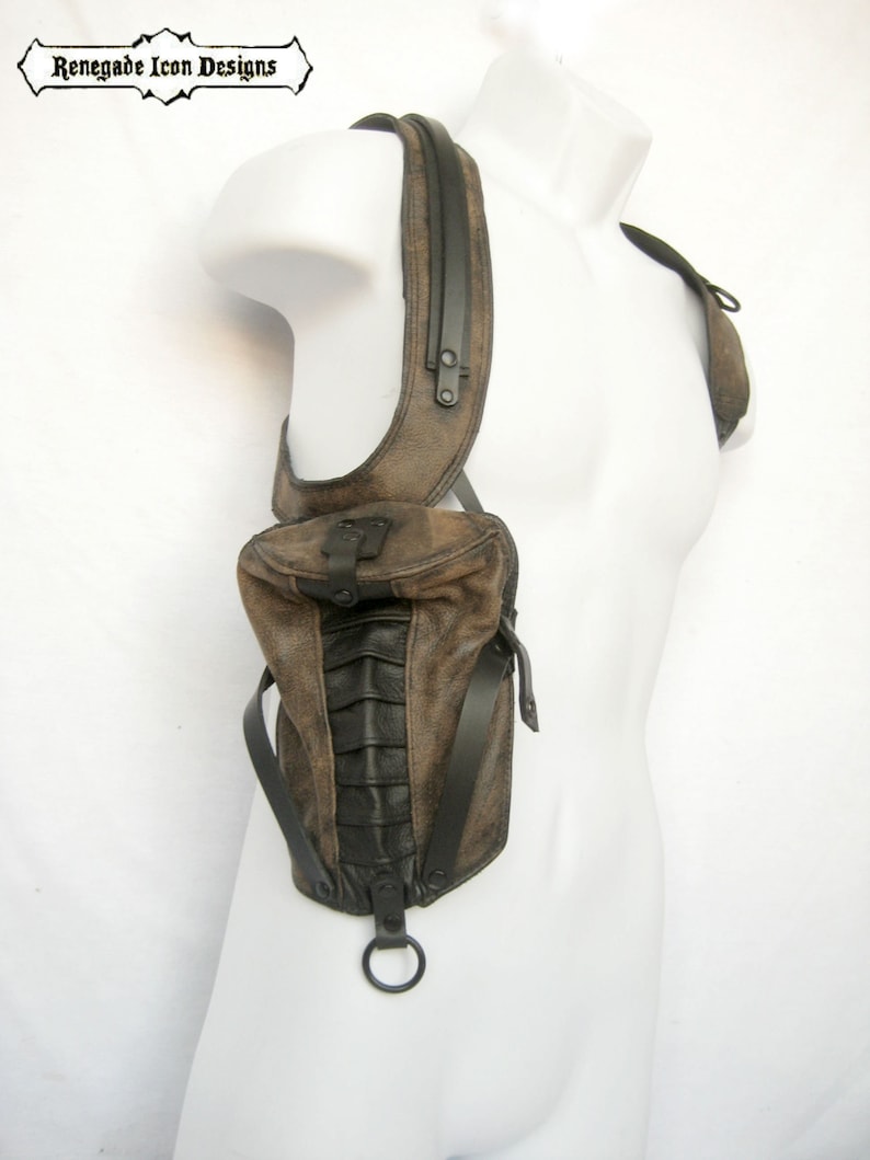 May include: A brown leather shoulder bag with black accents and a metal ring. The bag has a flap closure and a strap that goes over the shoulder.