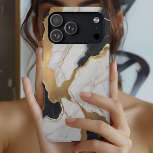May include: A smartphone case with a marble design. The case features a white background with black and gold veining. The camera lenses are visible on the top left of the case.