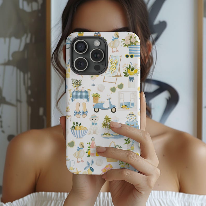 May include: A white iPhone case with a whimsical pattern of ducks, lemons, beach chairs, and a blue scooter. The case has a light blue border and a camera cutout. The design is in shades of yellow, blue, and white.