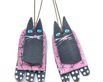 Retro black kitty earrings on bubble gum pink starburst
