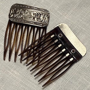 May include: Two antique hair combs. One has a silver rectangular top with floral designs. The other comb has a dark brown plastic comb with a rectangular top. Both combs have long, thin teeth.