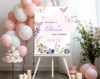 Puede incluir: Un cartel de bienvenida rosa y blanco con mariposas y flores para un baby shower. El cartel dice "Bienvenido al baby shower de Olivia" con la fecha y la hora del evento.