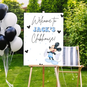 May include: Welcome to Jack's Clubhouse! A white sign with blue and black accents features a cartoon Mickey Mouse in a blue outfit. The sign is on a wooden easel in front of a green lawn.