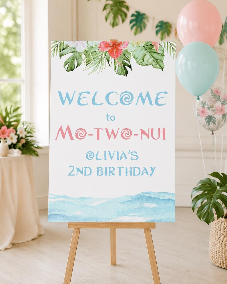 K&ouml;nnte beinhalten: Ein wei&szlig;es Willkommensschild auf einer Holzstaffelei, verziert mit tropischen Blumen und Bl&auml;ttern. Auf dem Schild steht "WELCOME to Mo-TWO-NUI @OLIVIA'S 2ND BIRTHDAY" in blauer und rosa Schrift. Ballons in Rosa, Blau und transparent mit Blumendesigns sind im Hintergrund.