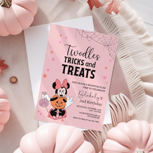 May include: A pink invitation with the text "Twodles Tricks and Treats" for a 2nd birthday party. The invitation features a cartoon character holding a pumpkin and a bag of candy, with pink pumpkins and fall leaves in the background.