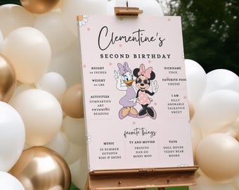 Könnte beinhalten: Ein rosa-weißes Geburtstagsschild mit rosa Hintergrund und weißen Punkten. Das Schild trägt die Aufschrift "Clementine's Second Birthday" und zeigt ein Cartoon-Bild von Minnie Mouse und Daisy Duck. Das Schild enthält auch Informationen über Clementines Größe, Gewicht, Aktivitäten, Lieblingsdinge und Persönlichkeitsmerkmale.