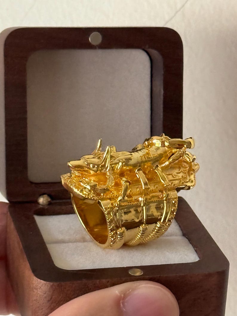 Puede incluir: Un anillo de oro con un dise&ntilde;o detallado de un escorpi&oacute;n. El anillo est&aacute; en una caja de madera.