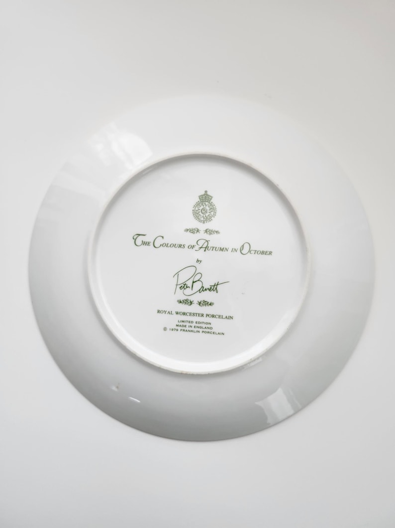 May include: White porcelain plate with the text "The Colours of Autumn in October" and the signature "Ron Barrett". The plate is a limited edition from Royal Worcester Porcelain, made in England.