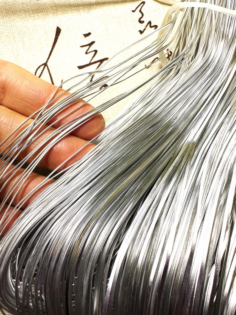 May include: A bundle of silver-coloured wire, likely used for crafting or jewellery making.