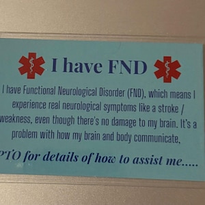 Könnte beinhalten: Eine rechteckige, hellblaue Karte mit dem Text "I have FND" und medizinischen Symbolen. Die Karte erklärt die funktionelle neurologische Störung (FND) und wie sie sich auf den Körper auswirkt. Der Text "PTO for details of how to assist me....." ist ebenfalls enthalten.