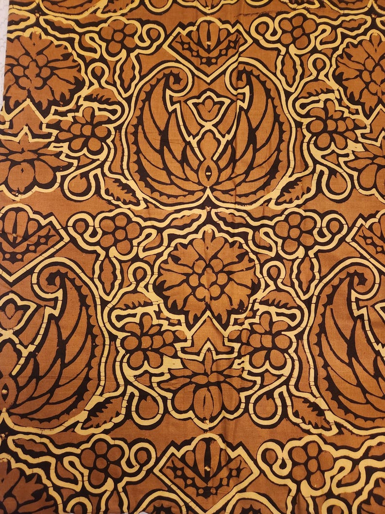 May include: Close-up of a fabric with a repeating pattern of stylized floral and leaf motifs in shades of brown and cream. The design features symmetrical arrangements with intricate details, creating a vintage or antique aesthetic.