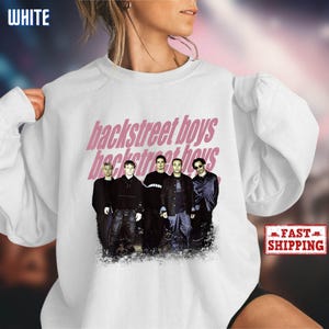 May include: White sweatshirt featuring the text "backstreet boys" in pink, with a photo of the band members. The word "WHITE" is in the upper left corner. A "FAST SHIPPING" sticker is in the lower right corner.