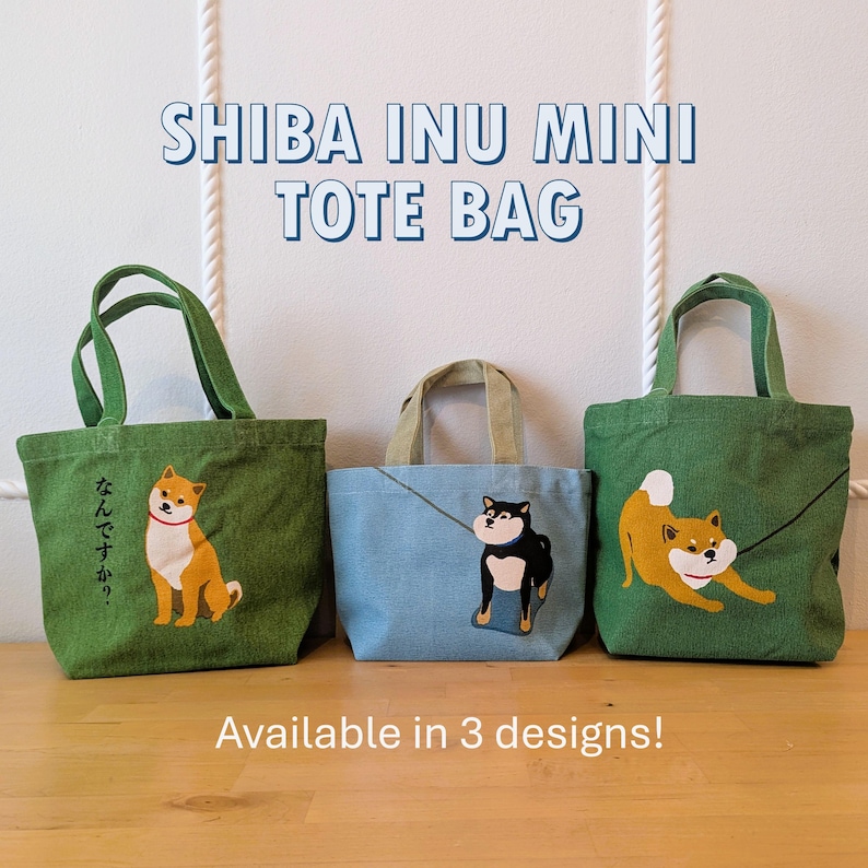 May include: Three green, blue, and green tote bags with Shiba Inu dog designs. The green bags have a Shiba Inu dog with the text "なんなんですか?" on one bag and a Shiba Inu dog with its tongue out on the other. The blue bag has a black Shiba Inu dog with its tongue out. The text "SHIBA INU MINI TOTE BAG" is at the top of the image. The text "Available in 3 designs!" is at the bottom of the image.