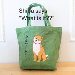 May include: Green canvas tote bag with a Shiba Inu dog illustration and the text "Shiba says "What is it?" and "なんですか?" in Japanese.