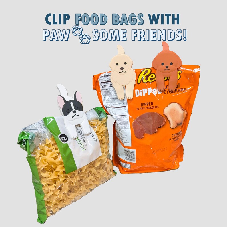 May include: Three colorful plastic bag clips shaped like dogs. The clips are holding a bag of pasta and a bag of chocolate-dipped crackers. The text on the bag of crackers reads "Dipped in Milk Chocolate".