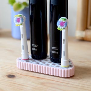 Podwójna kompaktowa elektryczna szczoteczka do zębów Oral-B z uchwytem na główkę i tacką ociekową – magnetyczna