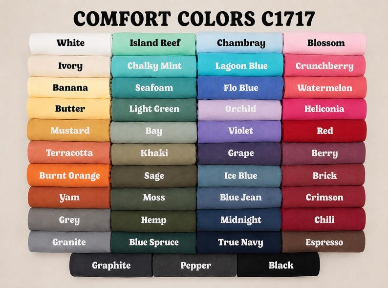 May include: A color chart for Comfort Colors C1717 t-shirts, displaying forty-four folded fabric swatches in various shades including white, ivory, yellow, orange, red, pink, purple, blue, green, grey, brown, and black, each labeled with its specific color name.