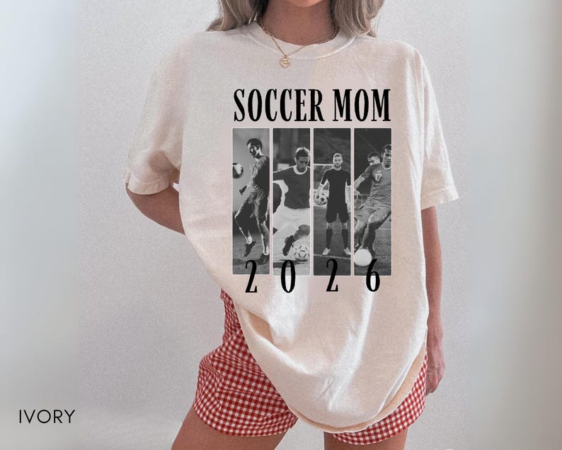 May include: Ivory-colored t-shirt with the text "SOCCER MOM 2026" in black. The design includes a collage of black and white soccer action shots. The shirt is a casual, oversized fit.