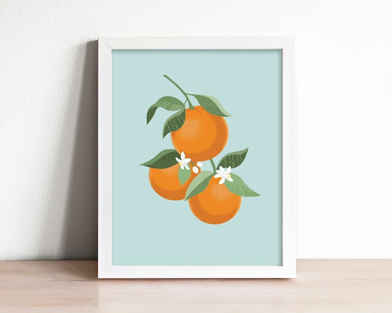 Pode incluir: Uma impress&atilde;o emoldurada de uma ilustra&ccedil;&atilde;o estilizada de tr&ecirc;s frutas c&iacute;tricas laranja em um galho com folhas verdes e flores brancas sobre um fundo azul claro.