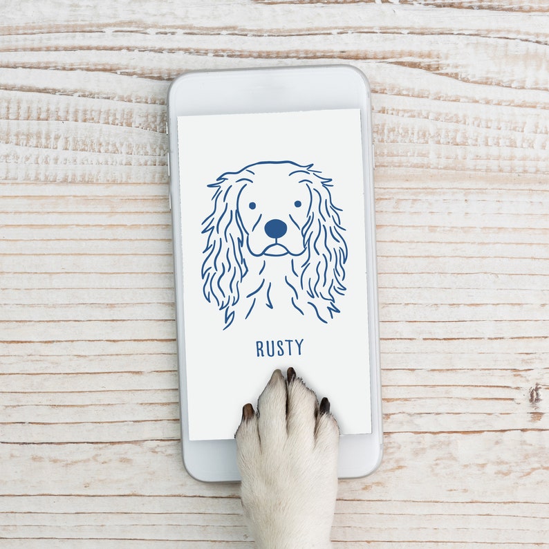 May include: A white smartphone with a blue outline of a dog's head and the word "RUSTY" on the screen. A dog's paw is touching the screen.