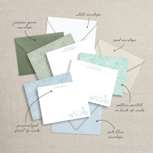 Puede incluir: Un juego de tarjetas de papeler&iacute;a personalizadas con un tema de animales de safari. Las tarjetas presentan un fondo azul claro con un patr&oacute;n de elefantes, jirafas y otros animales. La parte posterior de las tarjetas tiene un fondo verde con el mismo patr&oacute;n. El juego incluye sobres en blanco, azul p&aacute;lido, arena y verde enebro.