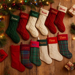 Puede incluir: Una colección de calcetines navideños personalizados en varios colores y patrones, incluyendo verde, rojo, crema y cuadros. Cada calcetín está bordado con un nombre diferente en un color contrastante, como "Emma", "Chloe" y "Oliver".