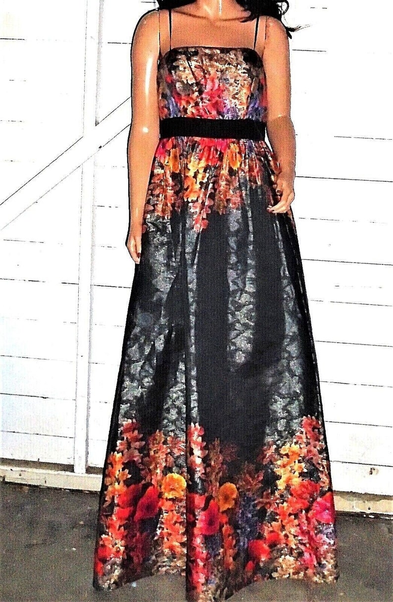 Puede incluir: Un vestido maxi negro con estampado floral. El vestido tiene un corpi&ntilde;o ajustado y una falda completa. El estampado floral es en tonos de rojo, naranja, amarillo y morado.