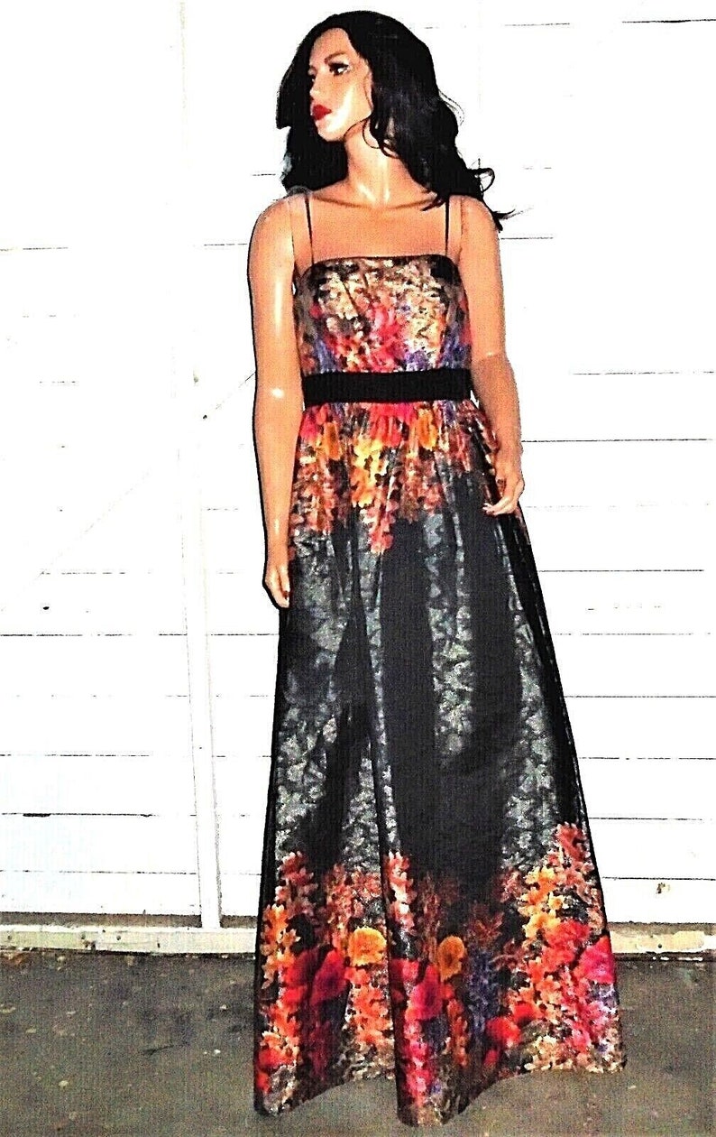 Puede incluir: Un vestido maxi negro con estampado floral. El vestido tiene un corpi&ntilde;o ajustado y una falda fluida. El estampado floral es en tonos de rojo, naranja, amarillo y morado.