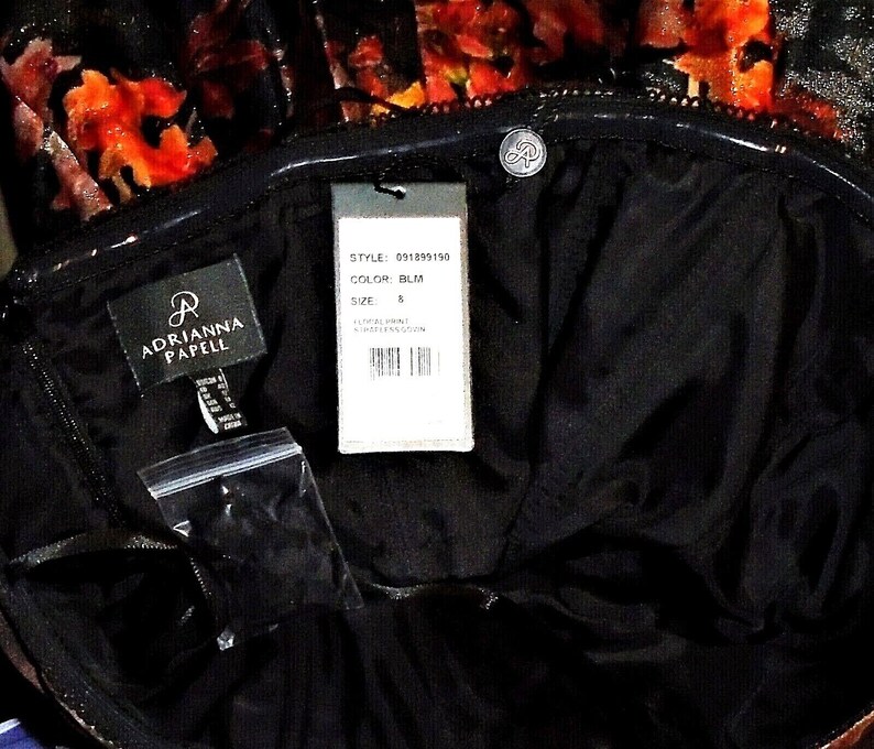 Puede incluir: Un vestido negro con estampado floral y una etiqueta que dice "Adrianna Papell" y "Style: 091839190, Color: BLM, Talla: 8".