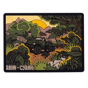 Könnte beinhalten: Ein schwarzer und grüner gestickter Aufnäher mit einer militärischen Szene. Der Aufnäher zeigt einen Militärlastwagen, der durch eine Dschungellandschaft fährt, mit Soldaten in Tarnkleidung. Der Text "ABIH - SUDAN" befindet sich am unteren Rand des Aufnähers.