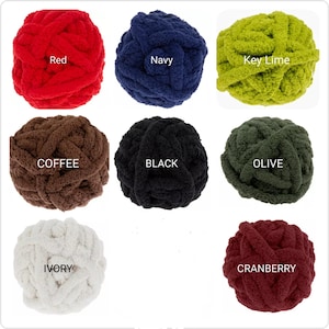 Puede incluir: Ocho ovillos de lana de chenilla gruesa en varios colores etiquetados como Red, Navy, Key Lime, Coffee, Black, Olive, Ivory y Cranberry. Cada ovillo presenta una textura gruesa, suave y afelpada, dispuestos en una cuadr&iacute;cula para elegir.